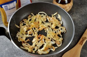 Хот-дог с жареным луком и солёными огурцами на сковороде Хот-дог с жареным луком и солёными огурцами на сковороде